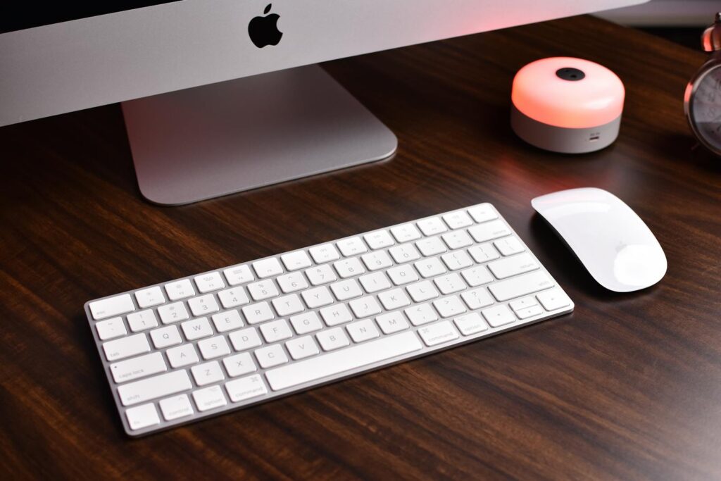 Sleek modern workspace featuring a computer keyboard, mouse, and ambient light on a wooden desk.